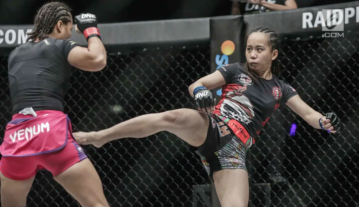 Petarung putri Malaysia, Audreylaura Boniface (kanan) melakukan tendangan ke petarung Indonesia, Priscilla Hertati Lumban Gaol (kiri) saat berlaga pada partai pertama One Championship di Jakarta, Sabtu (20/1). (Liputan6.com/Faizal Fanani)
