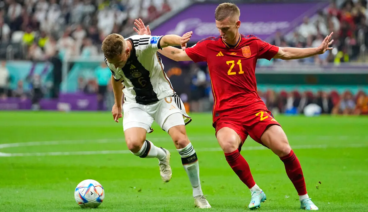 Pemain Jerman Joshua Kimmich (kiri) berebut bola dengan pemain Spanyol Dani Olmo pada pertandingan sepak bola Grup E Piala Dunia 2022 di Stadion Al Bayt, Al Khor, Qatar, 27 November 2022. Pertandingan berakhir imbang 1-1. (AP Photo/Julio Cortes)