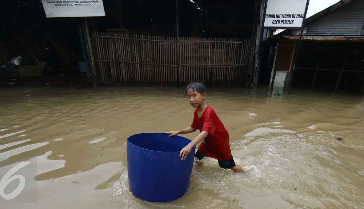 Seorang anak berada di tengah banjir di jalan Merpati Raya kota,Tangerang Selatan, Selasa (21/2). Intensitas curah hujan yang tinggi di sertai buruknya Drainase menyebabkan banjir 50-100 cm di kawasan tersebut. (Liputan6.com/Helmi Afandi)