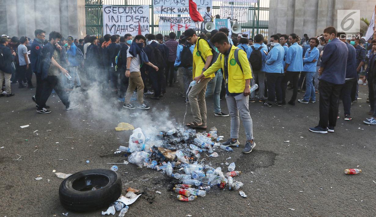 Mahasiswa dari berbagai kampus membakar botol plastik saat menggelar demonstrasi di Gedung DPR/MPR, Jakarta, Kamis (19/9/2019). Mahasiswa membakar botol plastik sambil memukul dan mendorong pagar Gedung DPR/MPR agar diizinkan masuk bertemu anggota dewan. (Liputan6.com/JohanTallo)