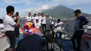 Sejumlah pemain dan staf Malut United berfoto bersama di atas kapal ferry dengan latar belakang gunung ketika menuju Tidore, Maluku Utara. (Bola.com/Okie Prabhowo)
