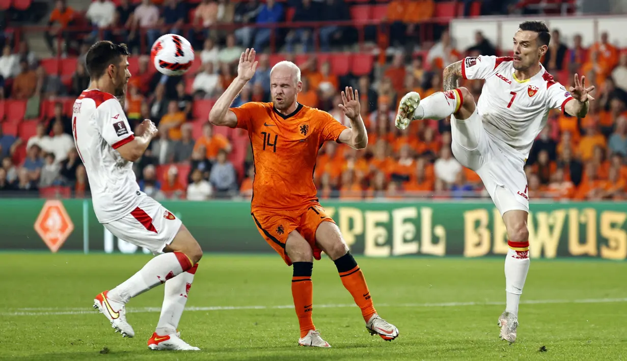 Pemain Montenegro, Dusan Lagator dan Marko Vesovic berebut bola dengan penyerang timnas Belanda, Davy Klaassen pada laga lanjutan kualifikasi Piala Dunia 2022 di Stadion Phillips, Minggu (5/8/2021) dini hari WIB. Belanda menggilas Montenegro empat gol tanpa balas. (MAURICE VAN STEEN/ANP/AFP)