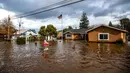 Banjir akibat badai mengelilingi rumah di Thornton Rd, Merced, California, Amerika Serikat, 10 Januari 2023. Serangkaian badai yang menghantam California telah menyebabkan jalanan terendam banjir, gelombang tinggi air laut, sungai meluap, dan memaksa ribuan orang untuk mengungsi. (AP Photo/Noah Berger)