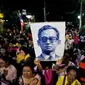 Rakyat Thailand membawa gambar Raja Thailand Bhumibol Adulyadej di luar RS Siriraj, Bangkok, Thailand, Kamis (13/10). (REUTERS / Jorge Silva)