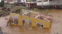 Sebuah rumah terhanyut setelah diterjang banjir bandang di Manado Sulawesi Utara.
