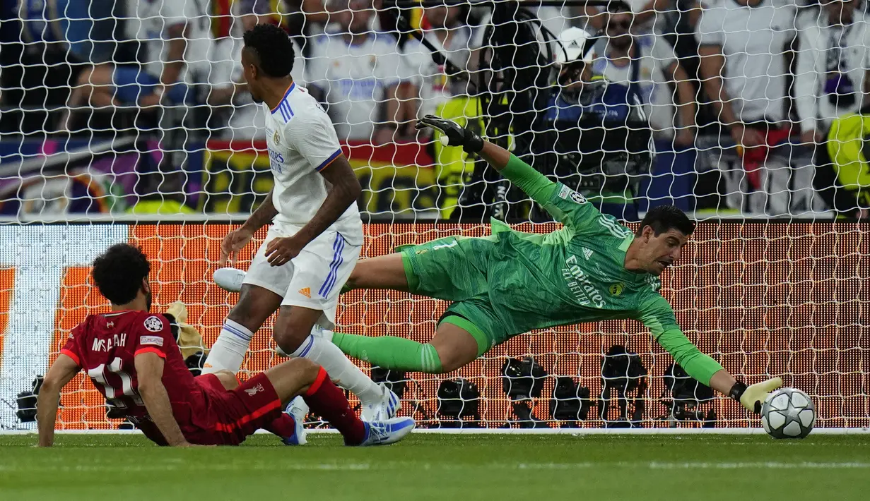 Penjaga gawang Real Madrid Thibaut Courtois berusaha menepis tembakan pemain Liverpool, Mohamed Salah saat laga final Liga Champions antara Liverpool melawan Real Madrid yang berlangsung di Stade de France, Saint Denis, Sabtu, 28 Mei 2022 waktu setempat. (AP/Petr David Josek)