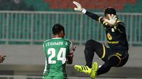 Pemain PS TNI, Legimin Raharjo berebut bola dengan kiper Barito Putra, Imam Arief Fadilah pada laga Torabika SC 2016 di Stadion Pakansari, Bogor, Jumat (22/7/2016). (Bola.com/Nicklas Hanoatubun)