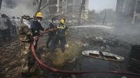 Petugas pemadam kebakaran bekerja di lokasi jatuhnya pesawat di kota Ahmedabad, negara bagian Gujarat, India Barat Laut, Kamis 12 Juni 2025. (AP/Ajit Solanki)