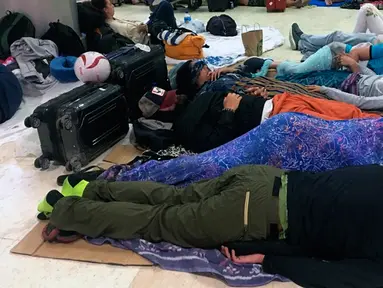 Turis asing tidur di lantai Bandara Internasional Lombok Praya di Pulau Lombok, NTB, Senin (6/8). Imbas gempa 7 skala Richter, para wisatawan mancanegara terlantar di bandara karena jam pemberangkatan pesawat yang tertunda. (AP/Niniek Karmini)