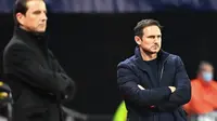 Dua pelatih, Frank Lampard (kanan/ Chelsea) dan Julien Stephan (Rennes) fokus mengamati jalannya pertandingan dalam laga lanjutan Liga Champions 2020/21 di Roazhon Park Stadium, Rennes, Rabu (25/11/2020). Chelsea menang 2-1 atas Rennes. (AFP/Damien Meyer)