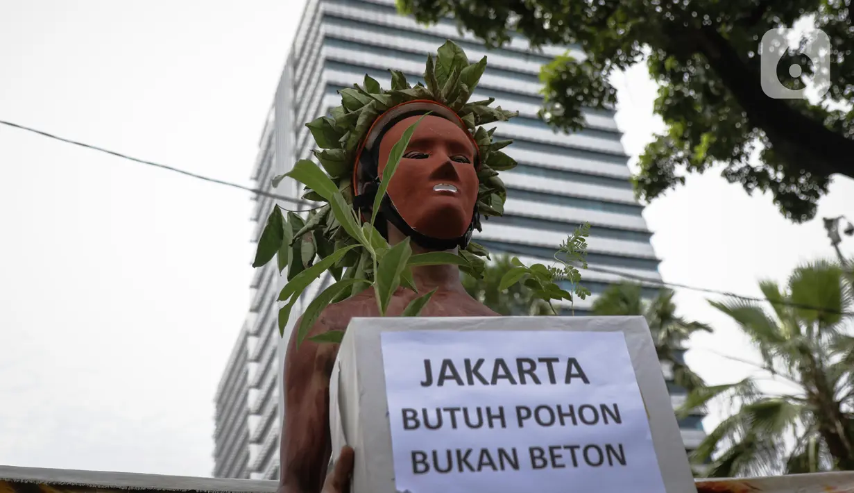 Aktivis Walhi membawa pohon saat menggelar aksi terkait proyek revitalisasi kawasan Monas di depan Balai Kota DKI Jakarta, Kamis (30/1/2020). Selain minta dihentikan, mereka juga mendesak kawasan Monas dikembalikan ke fungsi awal sebagai ruang terbuka hijau (RTH). (Liputan6.com/Faizal Fanani)