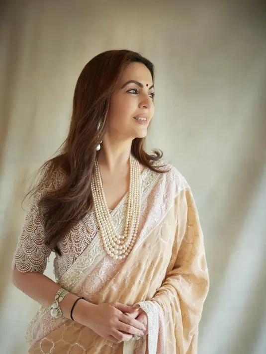Nita Ambani memancarkan pesona awet muda di usianya yang menginjak 60 tahun. Ia tampil memukau dalam balutan adat Abu Jani Sandeep Khosla beige ghagra yang dihiasi pinggiran chikankari.  [@abujanisdeepkhosla]