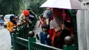 Sejumlah orang berjalan saat beberapa penumpang memanjat pagar pembatas di Stasiun Cikini, Jakarta, Rabu, (20/12). Akses pintu keluar stasiun yang terlalu jauh membuat banyak penumpang mencari jalan pintas dengan melompat pagar. (Liputan6.com/Johan Tallo)