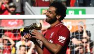 Penyerang Liverpool, Mohamed Salah, mengankat trofi Sepatu Emas Premier League usai laga melawan Brighton & Hove Albion di Stadion Anfield, Minggu (13/5/2018). Salah menjadi top scorer Premier League musim ini dengan raihan 32 gol. (AFP/Paul Ellis)
