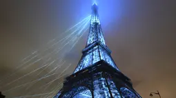 Menara Eiffel yang menjadi ikon kota Paris itu tampak begitu indah dengan bermandikan cahaya warna warni. (Luis Robayo/Pool Photo via AP)