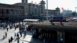 Orang-orang tiba di stasiun kereta api Beijing pada hari terakhir libur nasional "golden week" pada Kamis (7/10/2021). Hari libur selama 8 hari pada 1-7 Oktober tersebut menjadi hari libur terbesar kedua di Cina setelah tahun  baru. (JADE GAO / AFP)