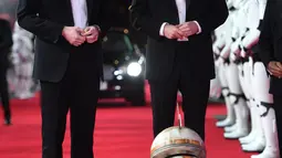 Pangeran William dan Pangeran Harry melihat robot droid BB-8 ketika berjalan di karpet merah premiere film The Star Wars: The Last Jedi yang digelar di The Royal Albert Hall, London, Inggris, Selasa (12/12). (Eddie Mulholland/Pool Photo via AP)