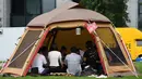 Foto 11 September 2018, karyawan perusahaan bekerja di dalam tenda kemah di halaman luar gedung kantor di Tokyo. Beberapa kantor di Jepang membebaskan pegawainya untuk bekerja di mana saja, mulai dari tenda hingga tempat karaoke. (Toshifumi KITAMURA/AFP)