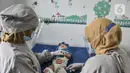 Dokter mengenakan APD lengkap saat memberikan imunisasi kepada balita di Puskesmas Kecamatan Jatinegara, Jakarta, Kamis (26/11/2020). (merdeka.com/Iqbal S. Nugroho)