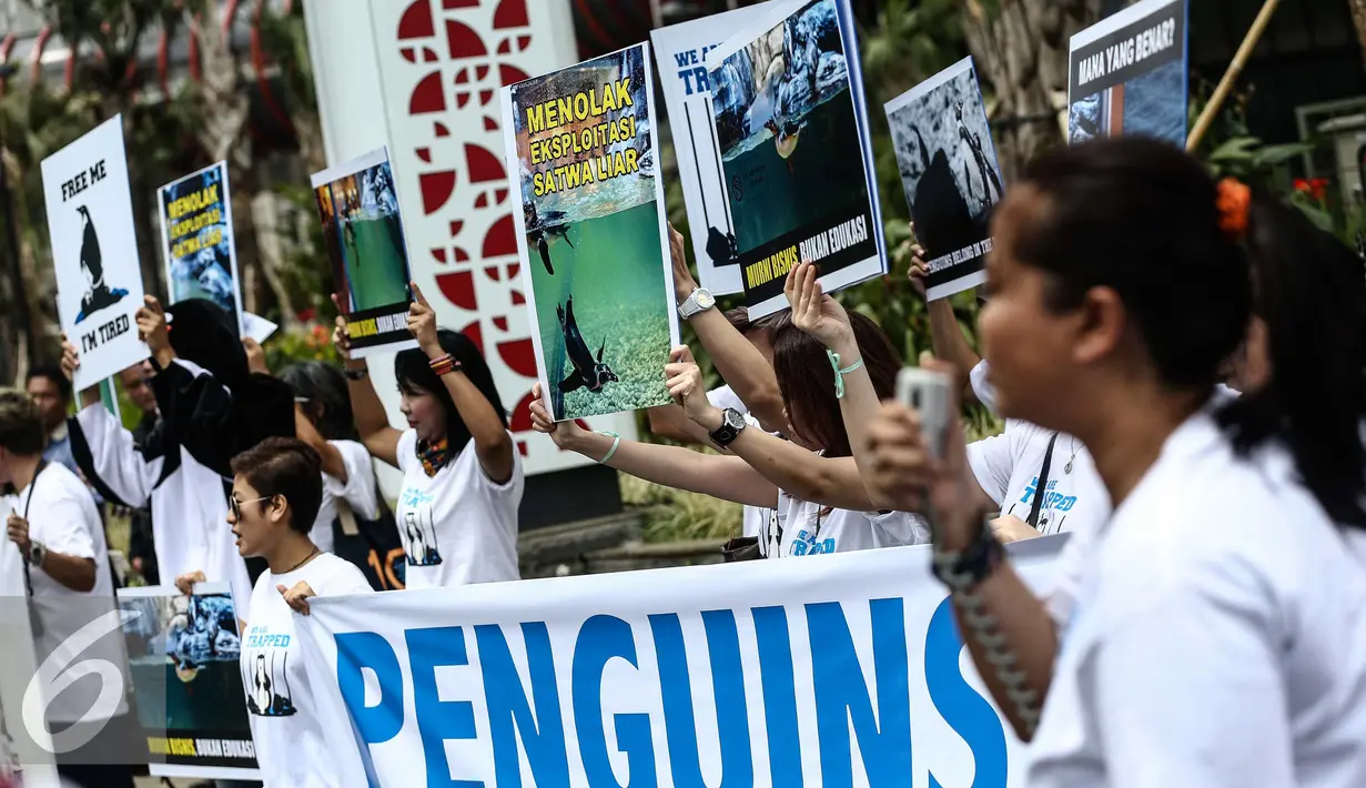 Aktivis dari Masyarakat Peduli Satwa (MPS)  membawa poster saat melakukan aksi di depan mall Neo Soho di kawasan Central Park, Jakarta Barat (15/01). (Liputan6.com/Faizal Fanani)