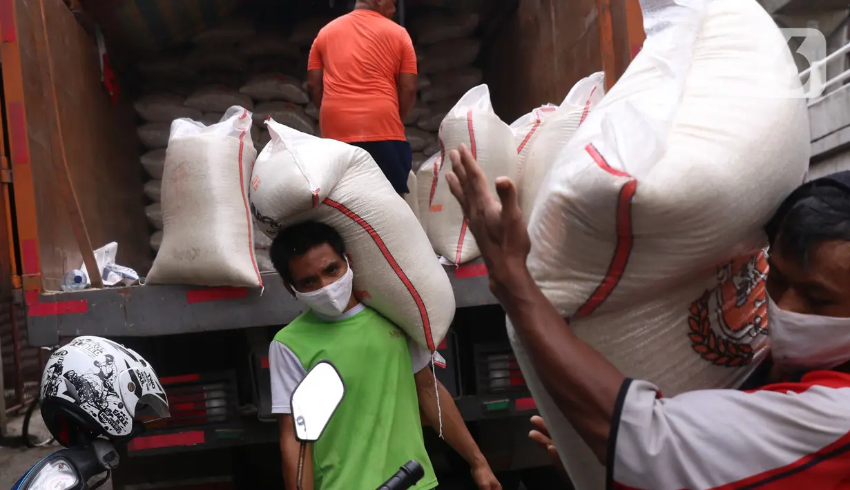 Pekerja tengah menurunkan beras yang akan di jual di Jakarta, Senin (21/12/2020). Kenaikan harga beras yang biasa terjadi saat momen akhir dan awal tahun diyakini tidak terjadi pada periode kali ini. (Liputan6.com/Angga Yuniar)
