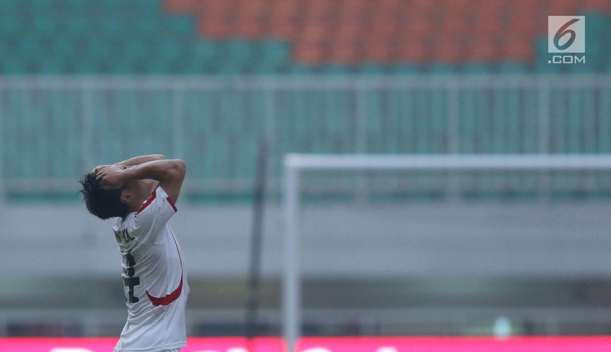Pemain Korea Utara, Kim Kum Chol memegang kepala saat laga melawan Bahrain pada PSSI Anniversary Cup 2018 di Stadion Pakansari, Kab Bogor, Kamis (3/5). Laga dimenangkan Bahrain 4-1. (Liputan6.com/Helmi Fithriansyah)