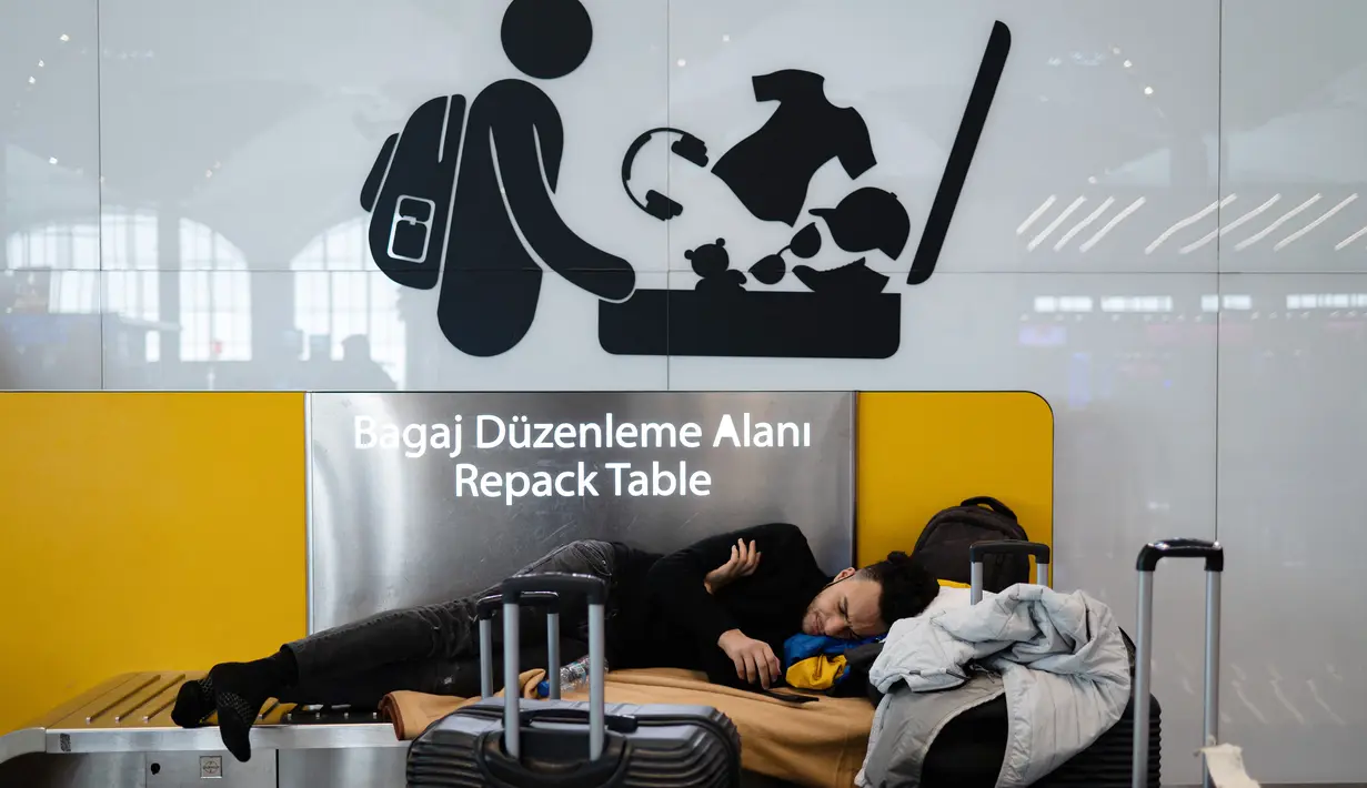 Penumpang yang terdampar menunggu di bandara Istanbul, di mana penerbangan dibatalkan karena badai salju dan hujan salju lebat, di Istanbul, Turki, pada 25 Januari 2022. Penutupan salah satu bandara tersibuk di Eropa ini akibat hantaman badai salju yang menghambat operasional. (Yasin AKGUL/AFP)