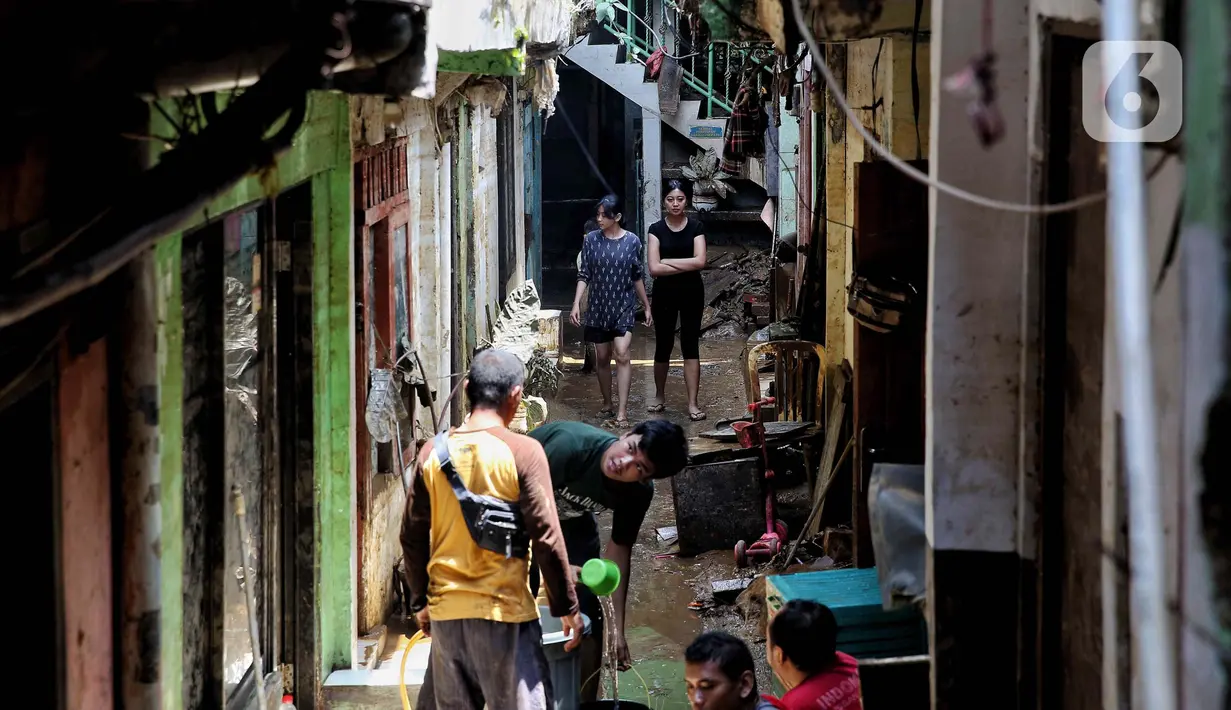 Warga mulai melakukan membersihkan material sisa dari banjir, yakni endapan lumpur serta barang-barang yang berserakan. (Liputan6.com/Angga Yuniar)