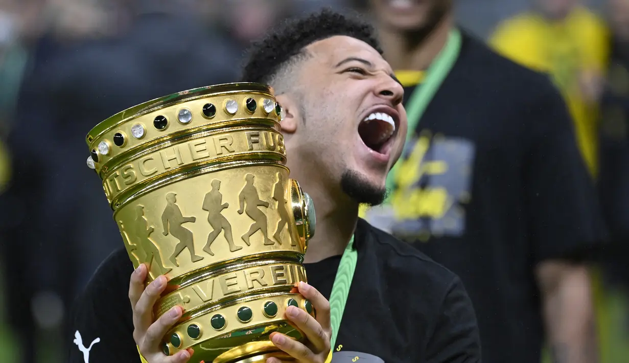 Gelandang Dortmund, Jadon Sancho memegang trofi setelah memenangkan pertandingan melawan RB Leipzig pada divisi satu Bundesliga di Berlin pada 13 Mei 2021. Kabar resminya Jadon Sancho ke Manchester United diumumkan melalui akun Twitter resmi klub. (AFP/Pool/John Macdougall)