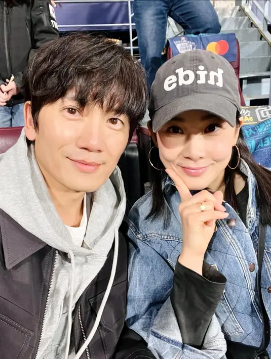 Pasutri Ji Sung dan Lee Bo Young juga tampil bersama menyaksikan pertandingan LA Dodgers Seoul Series ini. Ji Sung yang tampak tak menua tampil mengenakan kaus putih ditumpuknya dengan hoodie abu-abu dan jaket hitam. Tak kalah awet muda, Lee Bo Young tampil mengenakan kaus hitam lengan panjang yang ditumpuknya dengan denim jacket dan topi berwarna abu-abu. [Foto: Instagram/justin_jisung]