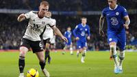 Gelandang Chelsea, Enzo Fernandez membayangi pemain Fulham Harrison Reed dalam pertandingan di Stamford Bridge, Sabtu (4/2/2023) dini hari WIB. (AP Photo/Kirsty Wigglesworth)