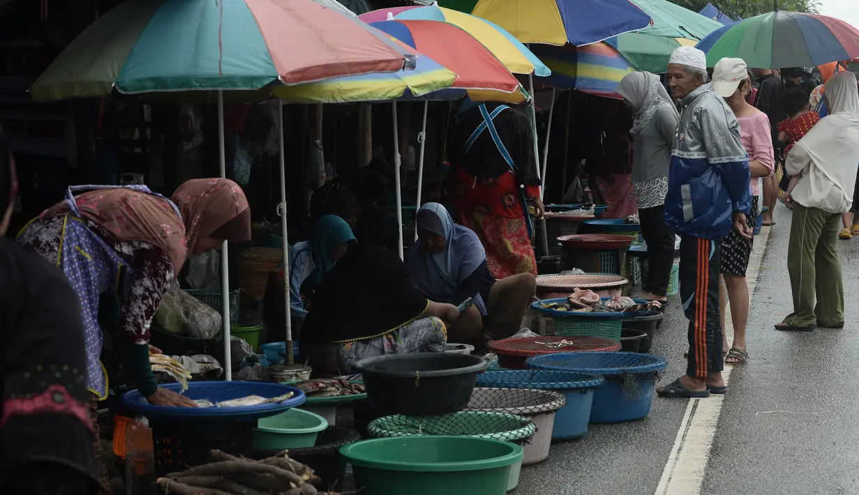 Sejumlah wanita muslim menjual ikan di pinggir jalan di Narathiwat, Thailand (19/12). Daerah ini sejak 4 Januari 2004 telah menjadi tempat terjadinya konflik antara pemerintah Thailand dan para separatis Muslim. (AFP Photo/Lillian Suwanrumpha)