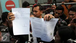 Pengacara Freddy Budiman, Untung Sunaryo memperlihatkan surat usai menjenguk Freddy Budiman di Lapas Nusakambangan, Jawa Tengah, Rabu (27/7). Freddy Budiman masih berharap Presiden bisa memberikan Grasi untuk dirinya. (Liputan6.com/Helmi Afandi)