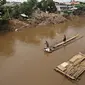 Warga saat menyebrangi Kali Ciliwung mengunakan eretan, Jakarta, Senin (30/11). Tidak adanya fasilitas jembatan menyebabkan warga memilih eretan sebagai sarana penyeberangan sehari-hari, meskipun dengan kondisi seadanya. (Liputan6.com/Immnuel Antonius)