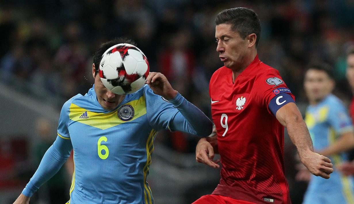 Pemain Kazakhstan, Yeldos Akhmetov (kiri) berduel dengan Robert Lewandowski saat Kualifikasi Piala Dunia 2018 di Astana Arena, Astana, (5/9/2016) dini hari WIB. Lewandowski mencetak satu gol saat Polandia imbang lawan Kazakhstan. (AFP/Stanislav Filippov)