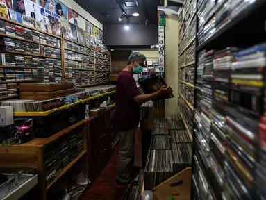 Pecinta musik memilah Piringan Hitam, CD, dan Kaset pita di toko "Wow Record Store", Blok M Squere, Jakarta, Jumat (12/3/2021). Pedagang Piringan Hitam, CD, dan Kaset Pita ini bertahan ditengah Perkembangan era digital dan Pandemi. (Liputan6.com/Johan Tallo)