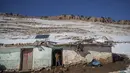 Ihsan (5) berdiri di luar rumahnya yang memiliki panel surya untuk menyediakan panas dan listrik, di desa Amazigh Timahdite di Atlas Tengah, dekat Azrou, Maroko (4/12/2021). Desa Timahdite Maroko yang terpencil, terletak di gunung tertinggi di Afrika Utara. (AP Photo/Mosa'ab Elshamy)
