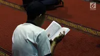 Umat muslim membaca Alquran saat malam takbiran di Masjid Istiqlal, Jakarta, Selasa (4/6/2019). Ratusan umat muslim berdatangan ke Masjid Istiqlal untuk merayakan malam takbir jelang melaksanakan salat Idul Fitri 1440 Hijriah. (Liputan6.com/Helmi Fithriansyah)