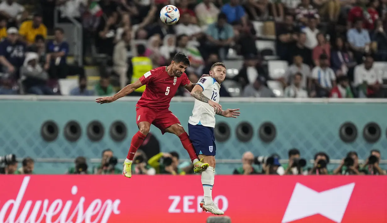 <p>Bek Inggris, Kieran Trippier berebut bola udara dengan pemain Iran, Milad Mohammadi selama pertandingan grup B Piala Dunia 2022 Qatar di Stadion Internasional Khalifa di Doha, Qatar, Senin (21/11/2022). Dengan kemenangan ini, Inggris berada di puncak klasemen dengan tiga poin. (AP Photo/Martin Meisner)</p>