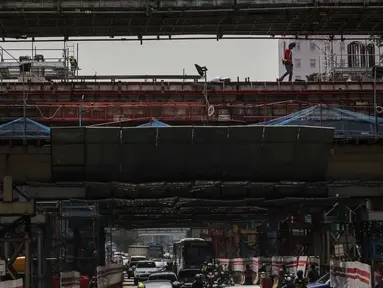 Pekerja konstruksi menyelesaikan pembangunan LRT Jabodebek rute Cawang-Dukuh Atas di Cawang, Jakarta, Jumat (8/3). Kementerian PUPR mengungkapkan ada sejumlah tantangan di sektor jasa konstruksi pada era Revolusi Industri 4.0. (Liputan6.com/Faizal Fanani)