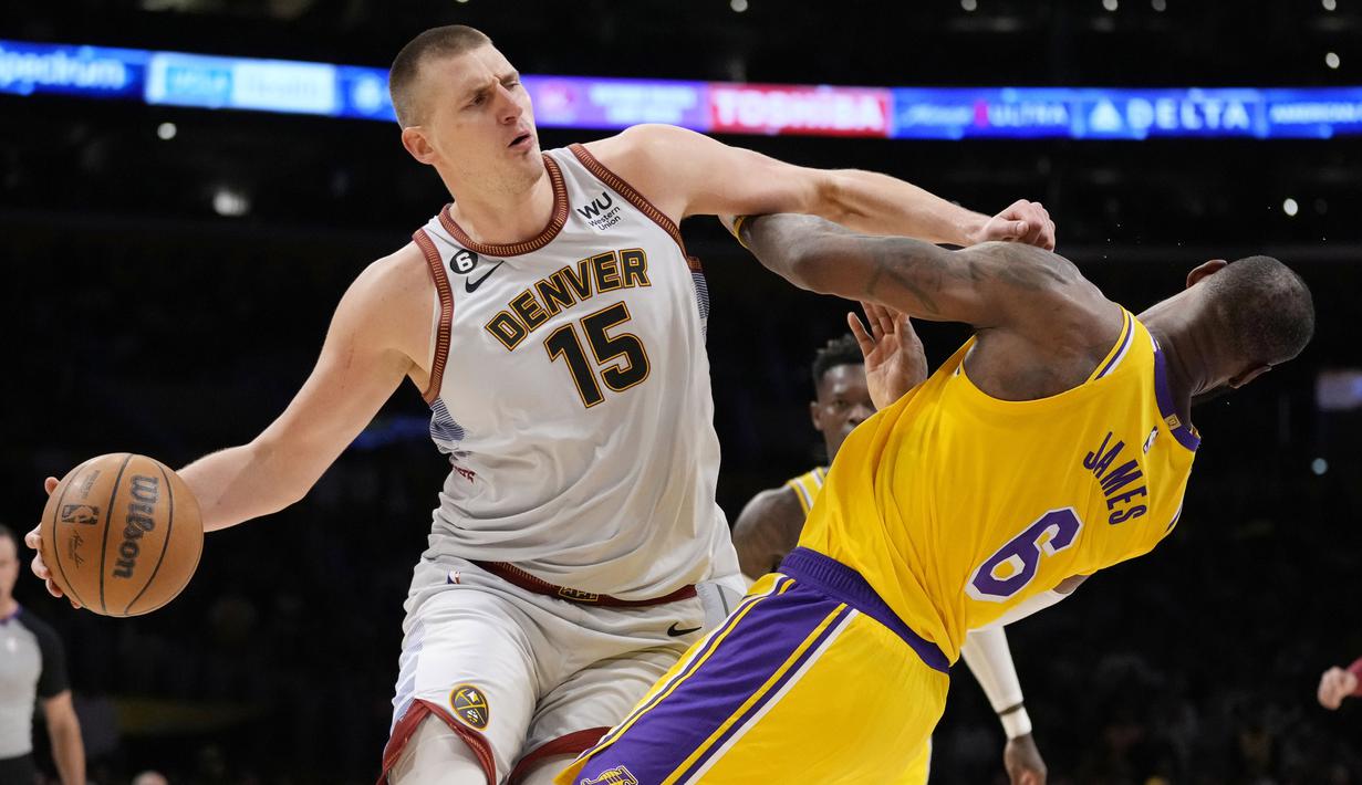 Pebasket Denver Nuggets, Nikola Jokic (kiri), berusaha melewati penjagaan pebasket LA Lakers, LeBron James, dalam final NBA 2023 game keempat wilayah barat di Crypto.com Arena, Selasa (23/5/2023) pagi WIB. (AP Photo/Ashley Landis)