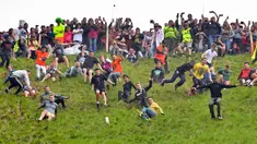 Peserta berlomba mengejar keju dalam kompetisi Cheese Rolling di Bukit Cooper, Gloucestershire, Inggris, Senin (27/5/2019). (Ben Birchall/PA via AP)
