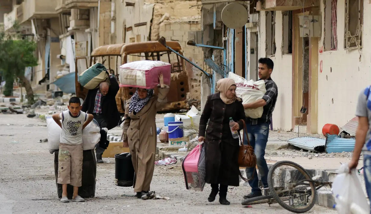 Ratusan warga sipil mulai kembali ke rumah mereka di kota modern Palmyra, berdekatan dengan kota kuno Suriah, Sabtu (9/4). Warga kembali ke rumah mereka setelah dibebaskannya dua kota tersebut dari tangan ISIS. (Louai BESHARA/AFP)