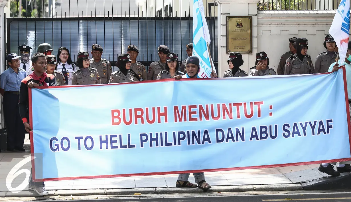 Para pengunjuk rasa membentangkan spanduk di depan Kedutaan Besar Filipina, Jakarta, Kamis (14/7).  Aksi ini juga digelar sebagai bentuk solidaritas kaum buruh terhadap ABK WNI yang disandera di Filipina. (Liputan6.com/Faizal Fanani)
