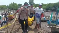 Petugas kepolisian bersama warga mengevakuasi  jenazah AF yang ditemukan di area Pantai Larangan Banyuwangi (Istimewa)
