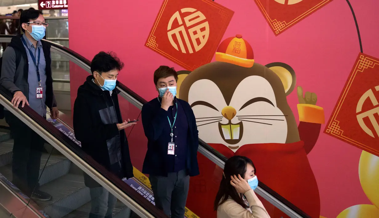 Orang-orang memakai masker saat menaiki eskalator di Bandara Internasional Hong Kong di Hong Kong, Selasa (21/1/2020). Masker terjual habis dan pemeriksaan suhu di bandara dan stasiun kereta api menjadi norma baru di China menyusul merebaknya wabah virus corona.  (AP/Ng Han Guan)