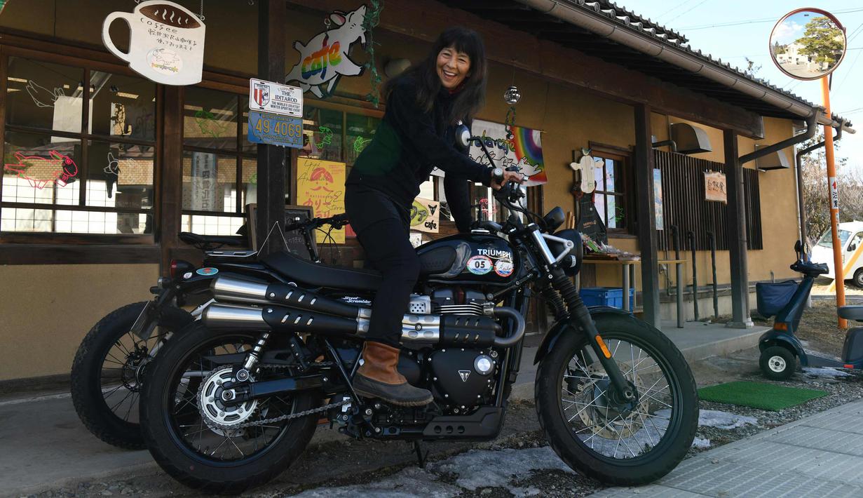 Reiko Miyoshi (60) berpose dengan motor Triumph Street Scrambler miliknya di luar "Perefa Cafe" di Matsumoto, prefektur Nagano (23/2). Miyoshi memulai petualangan pertamanya sepanjang 30.000 kilometer. (AFP Photo/Toshifumi Kitamura)
