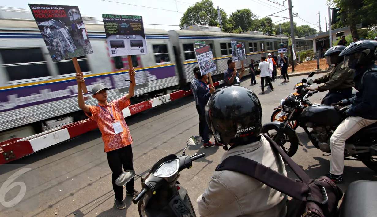 Aksi kampanye Komunitas Indonesian Railway Preservation Society di perlintasan kereta api di Menteng, Jakarta, Kamis (15/10). Kampanye itu guna menyadarkan masyarakat akan bahaya menerobos perlintasan kereta api. (Liputan6.com/Immanuel Antonius)