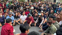 Ratusan mahasiswa dari berbagai perguruan tinggi di Solo Raya kembali menggelar aksi demonstrasi di depan Gedung DPRD Solo. Para mahasiswa mengajak anggota DPRD hingga Kapolresta Solo untuk duduk lesehan bersama di tengah Jalan Adi Sucipto. (Liputan6/Fajar Abrori)