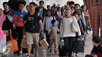 Ratusan pemudik berjalan menuju pintu kedatangan saat tiba di Stasiun Senen, Jakarta, Sabtu (9/7). Puncak arus balik pemudik di stasiun Senen diperkirakan terjadi pada besok Minggu (10/7). (Liputan6.com/Johan Tallo)
